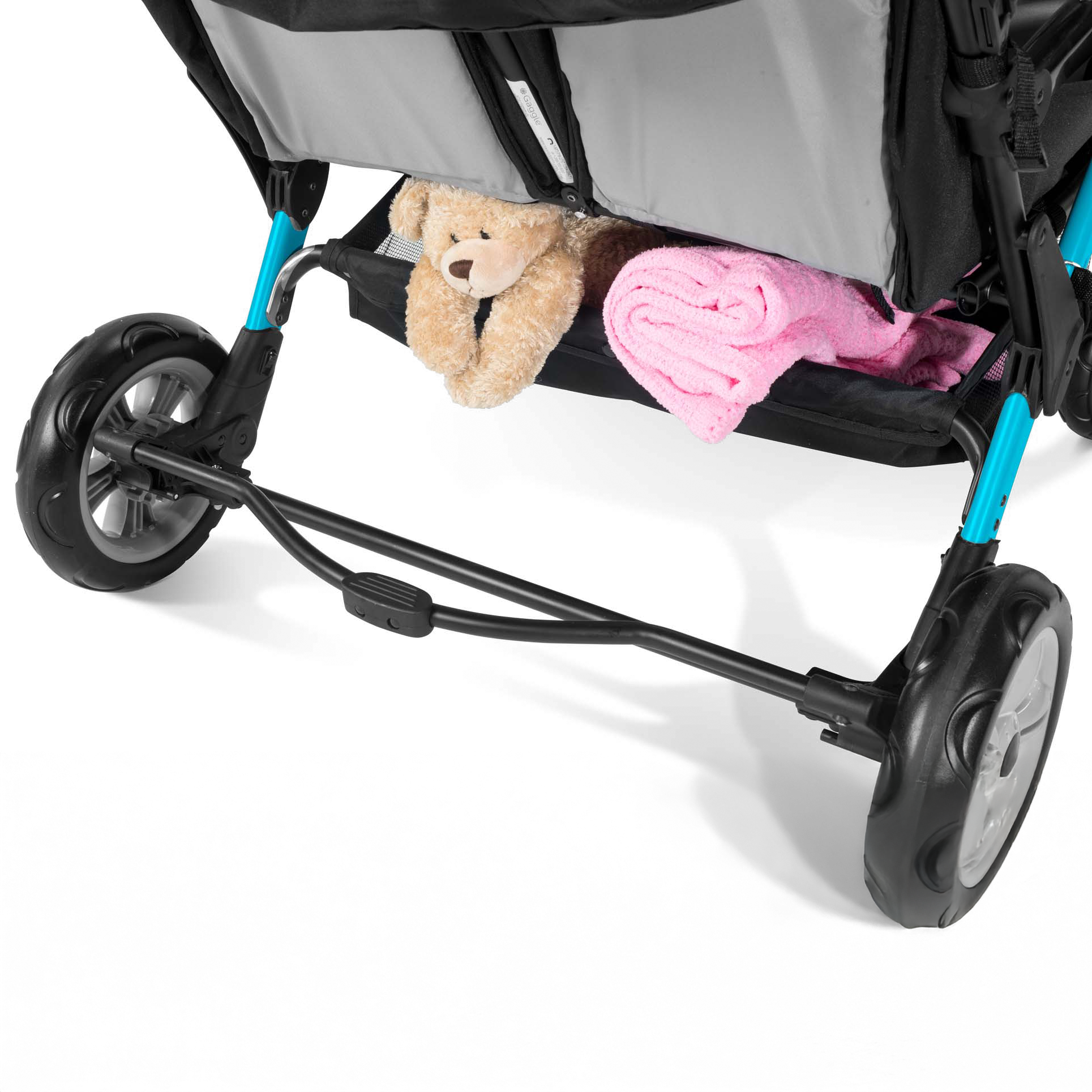 Close-up of a stroller storage basket with a teddy bear and pink blanket 