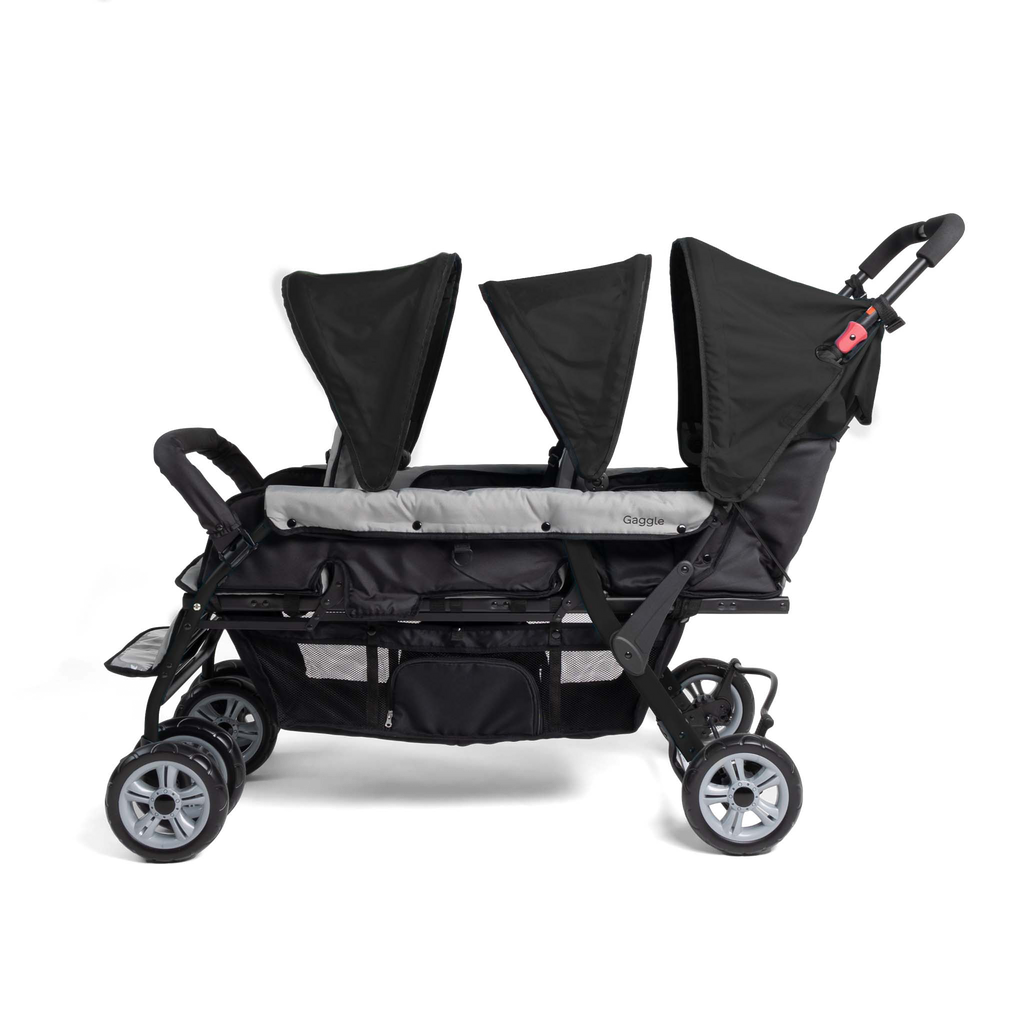 Side of triple stroller with black canopies 