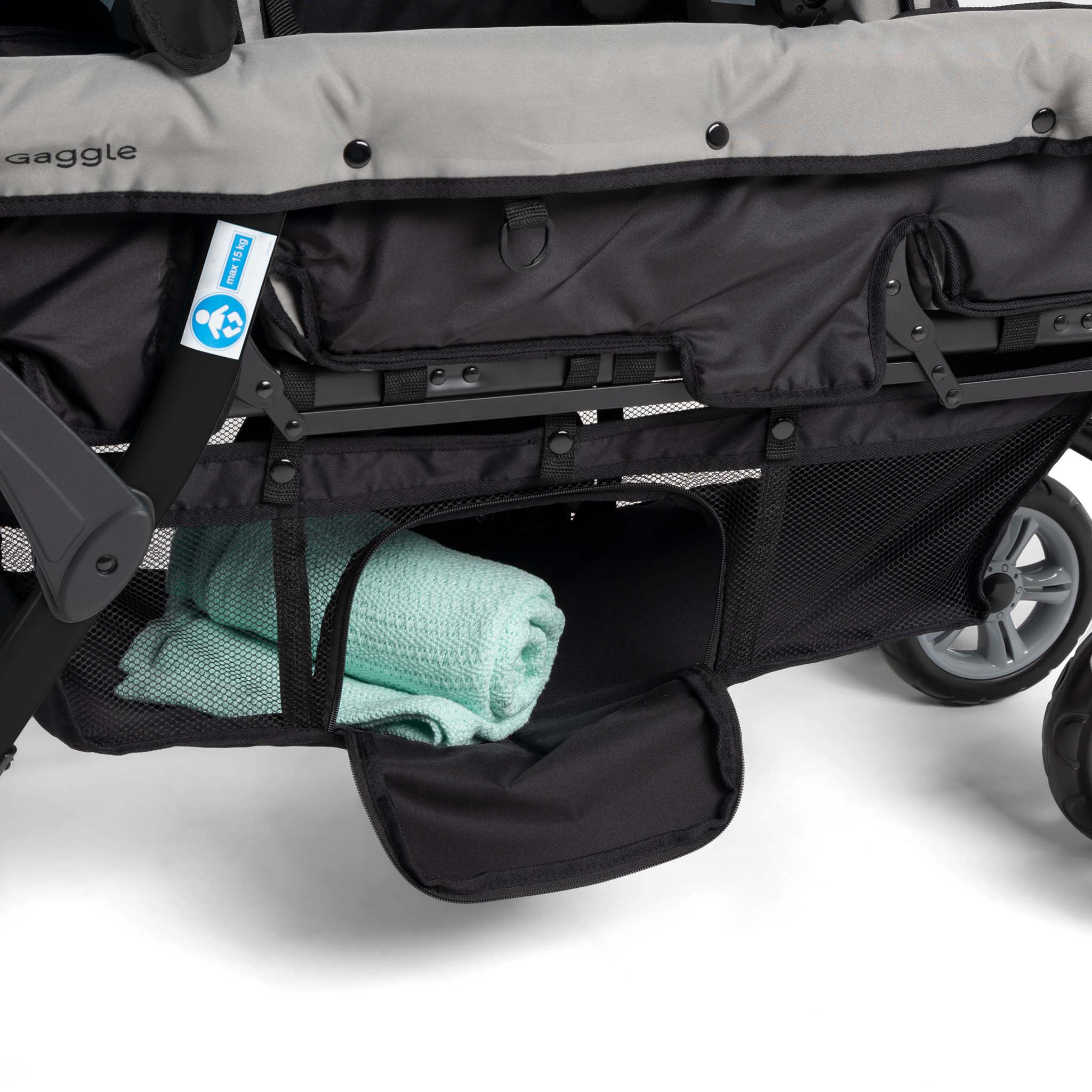 Close-up of a stroller with a green towel inside storage