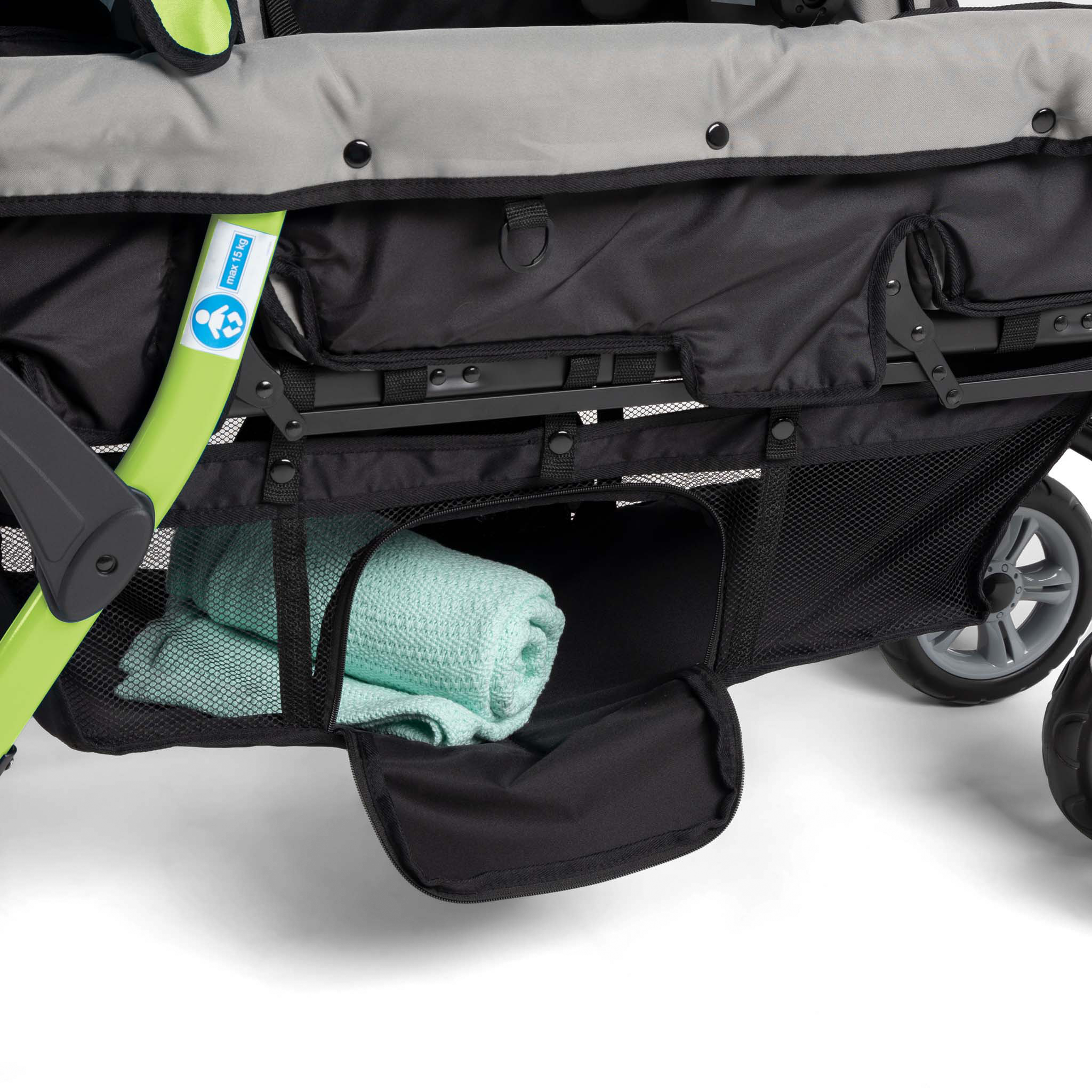 Close-up of a stroller with a green towel inside storage