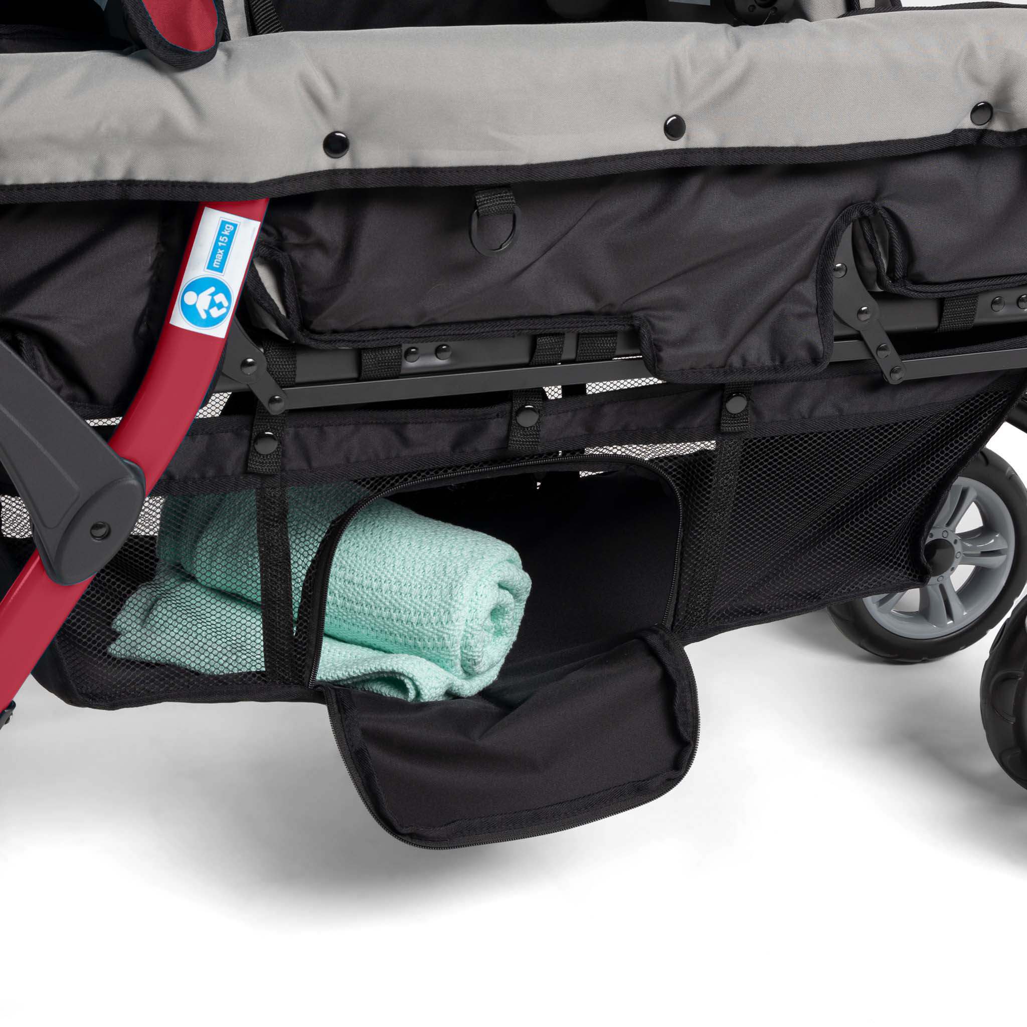 Close-up of a stroller with a green towel inside storage