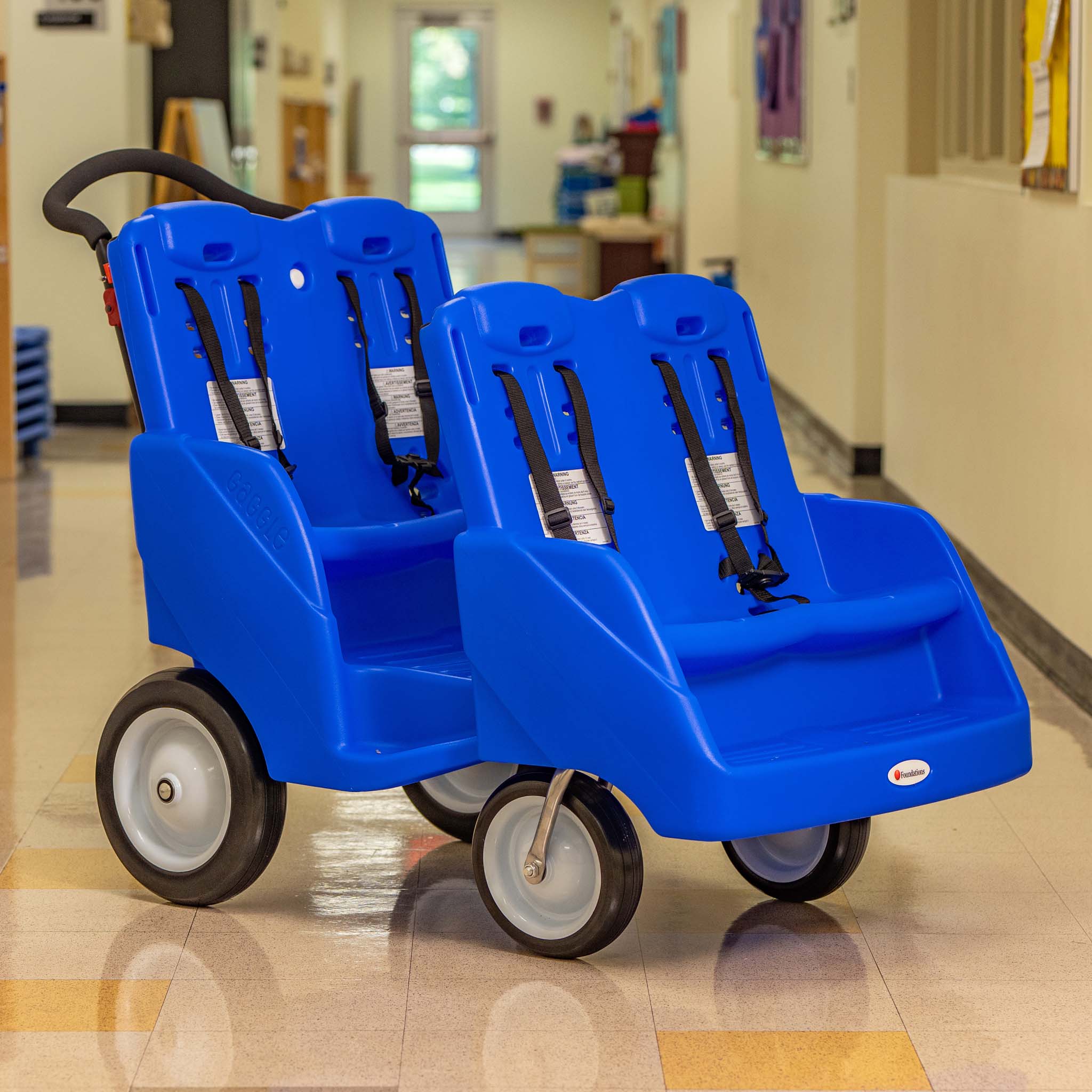 Blue kids's buggy with multiple seats in a hallway